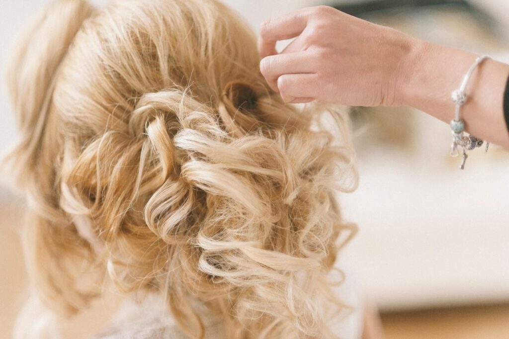 pexels photo 15507425 A professional hairstylist creates a blonde bridal updo for a wedding.