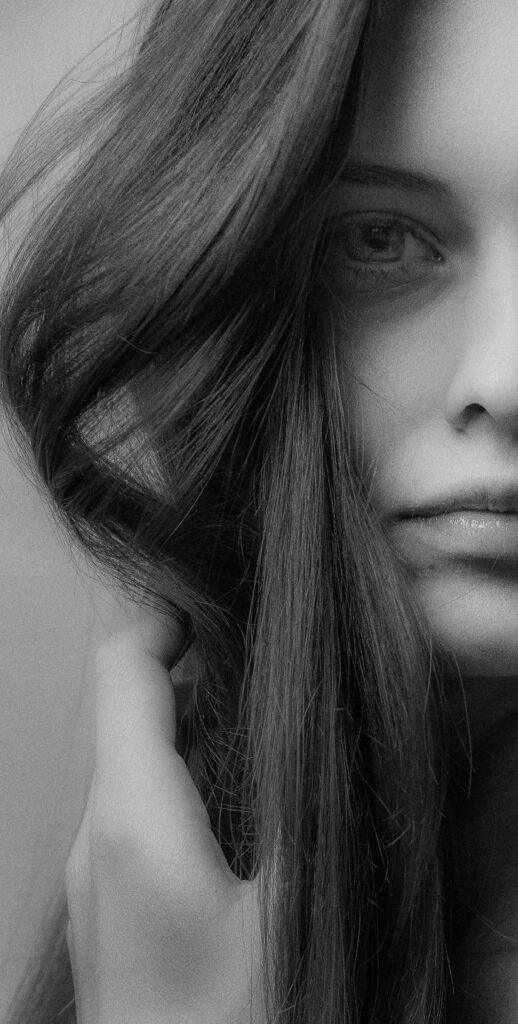 pexels photo 7032649 Striking black and white portrait of a woman showcasing her expressive eye and flowing hair.